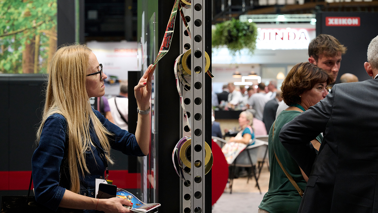 A woman examines a small roll of labels at Labelexpo