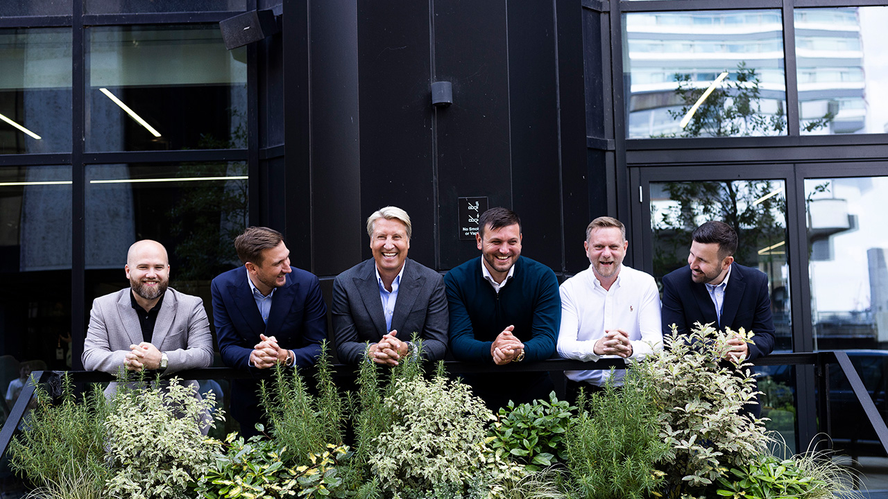 Brett Simpson, Lewis Cook, Mark Cook, Ashley Cook, Carl Brock and and Ed Holden stand at a handrail in front of a building