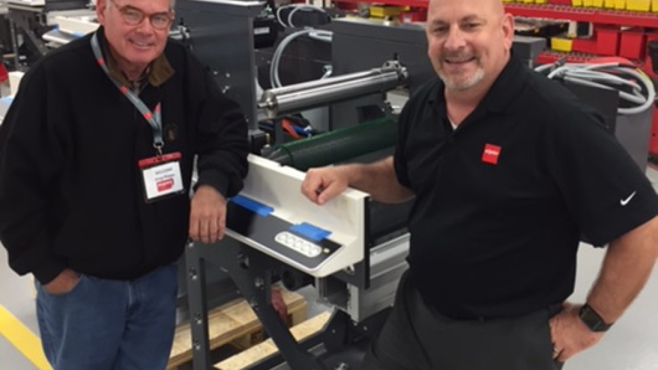 Greg Phipps of Phipps Label Co, and Bob Loescher of Nilpeter, standing by the all new FA on the assembly line at Nilpeter in Cincinnati, Ohio