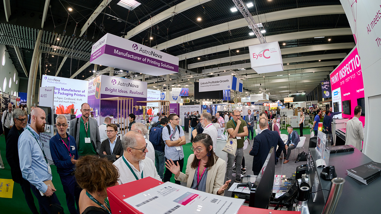 A woman at the EyeC booth speaks to two Labelexpo attendees