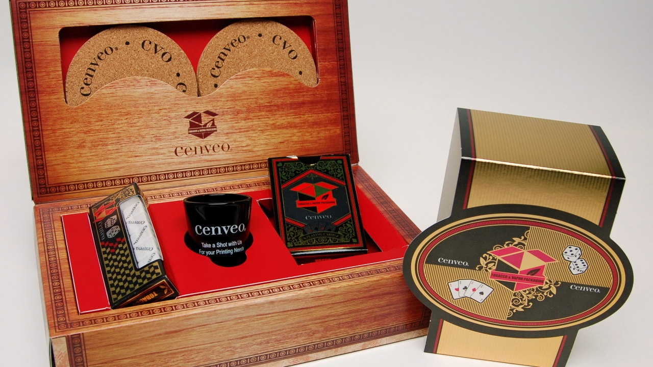 When opened, the wood effect box contains several Cenveo branded items, such as beverage coasters, a deck of playing cards, a carton with five dice and a shot glass When opened, the wood effect box contains several Cenveo branded items, such as beverage coasters, a deck of playing cards, a carton with five dice and a shot glass
