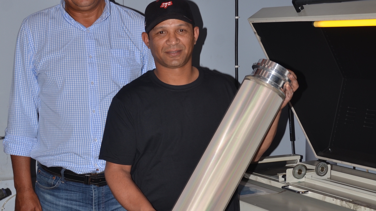 ColorScreen’s John Busch (left), who is responsible for sales and technical service, and Granville Solomons (right), within its screen making department pictured with an SPGPrints RotaMesh rotary screen