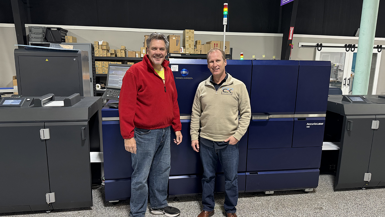Charles Kunkel and Jim Osborn stand in front of the Konica Minolta AccurioLabel 400