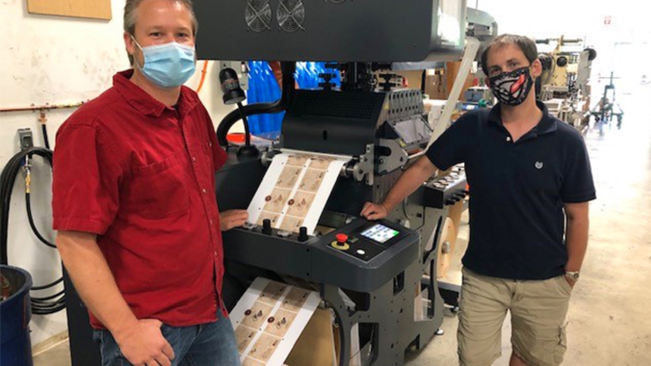 L-R: Jason Kuehl, director of production; John Pless, digital press and hot stamp operator in front of the recently installed Grafisk Maskinfabrik HOTFB330 standalone hot foil unit L-R: Jason Kuehl, director of production; John Pless, digital press and hot stamp operator in front of the recently installed Grafisk Maskinfabrik HOTFB330 standalone hot foil unit