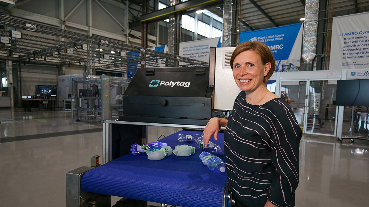 Alice Rackley next to plastic bottles on a conveyer belt