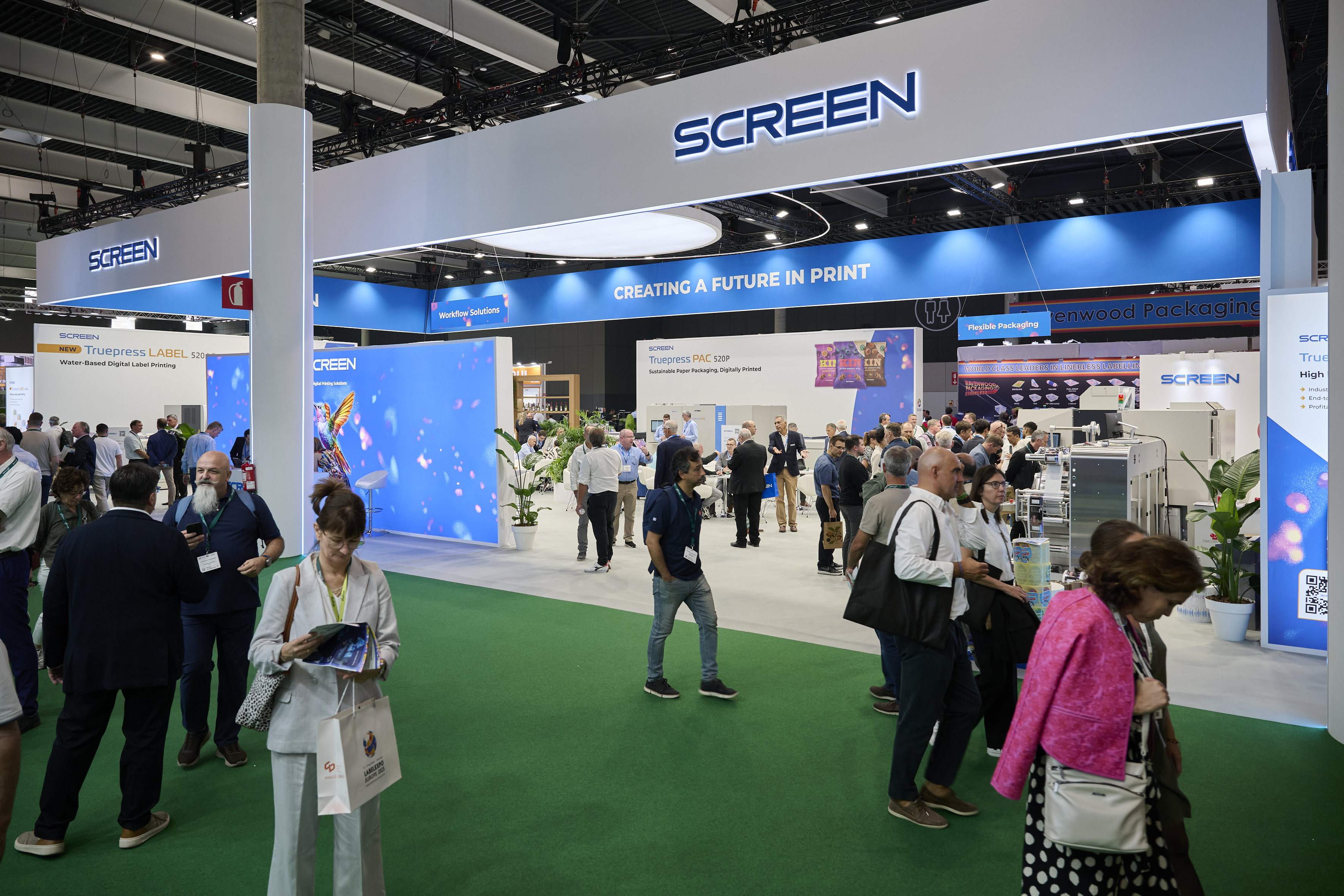 People walk past the Screen booth