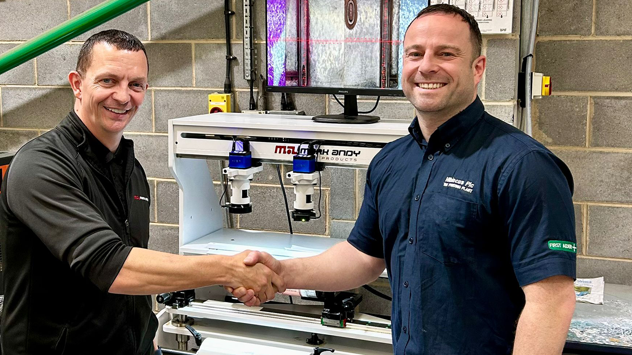 Andy Clarke and Jonathan Filin shake hands in front of plate mounter