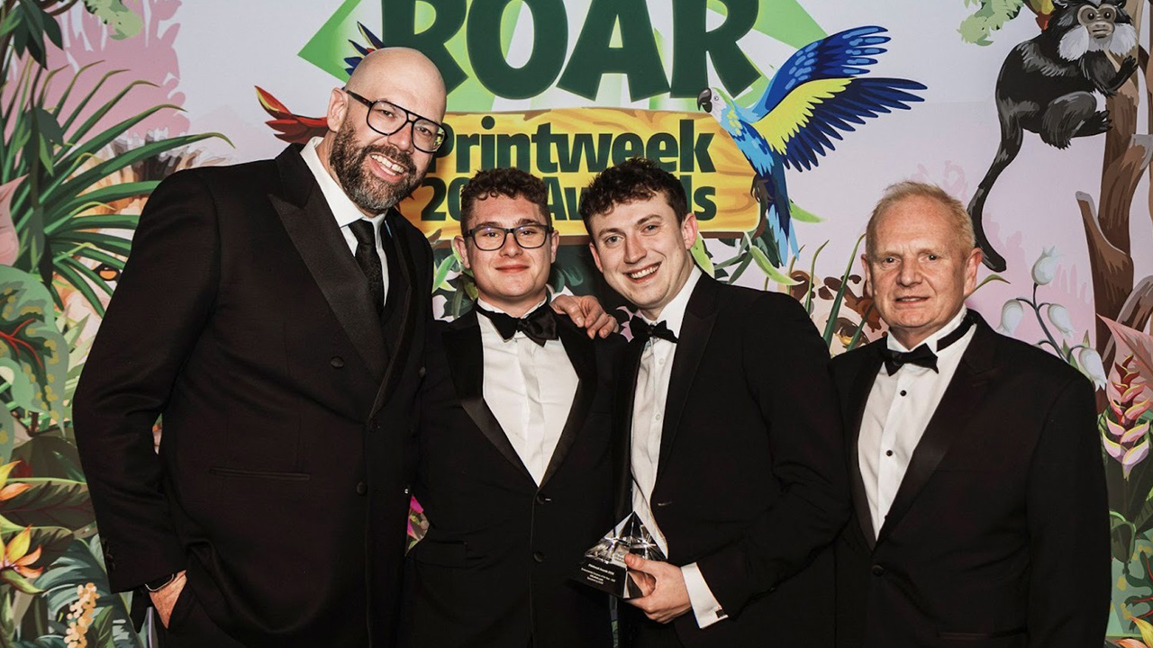 four men hold an award