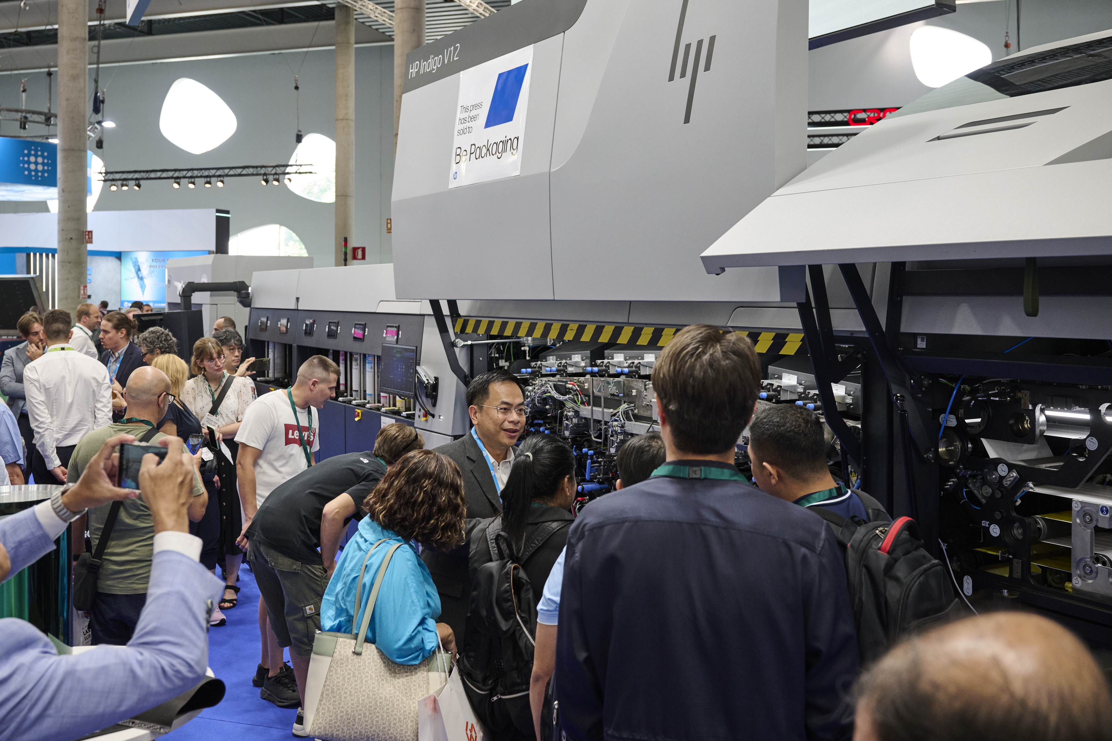 A crowd gathers around an open HP Indigo V12