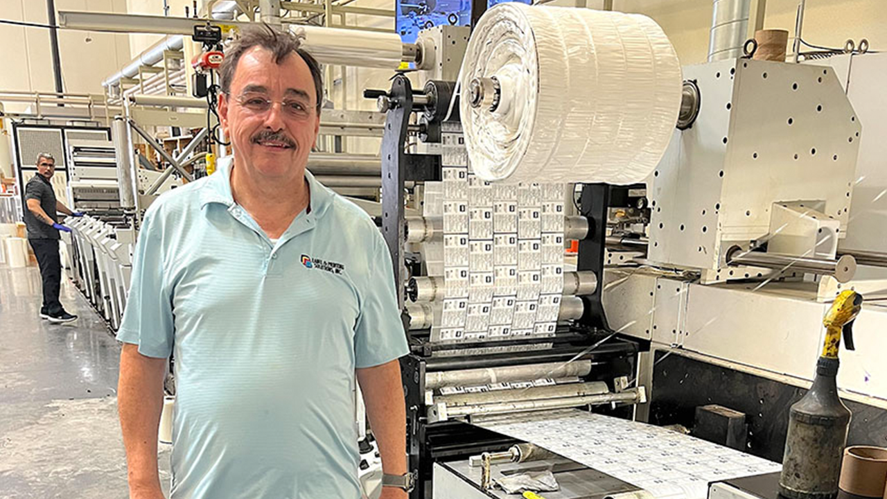 Ricardo Stone stands in front of his Mark Andy P7 press