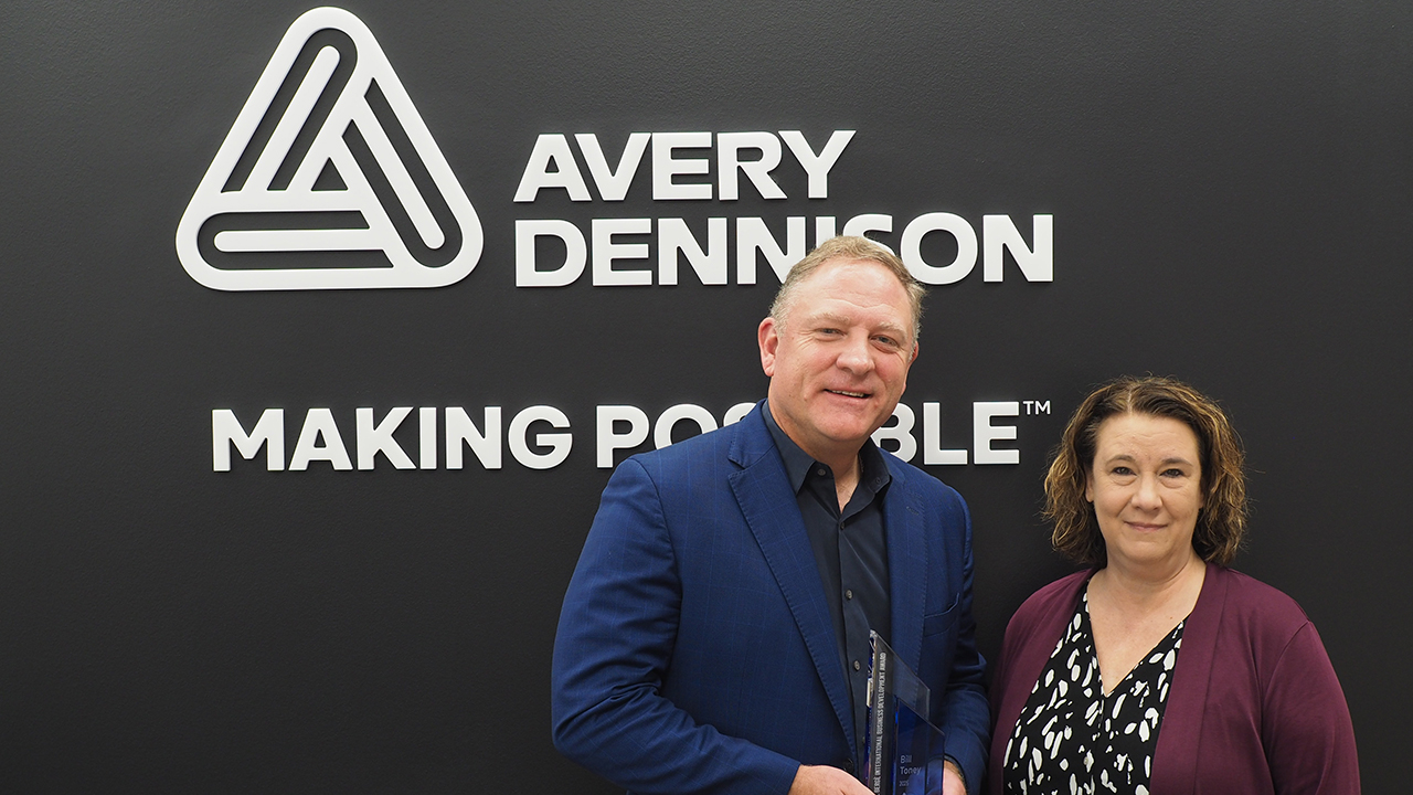 Bill Toney receives the award from Mary Lou Bosco, CEO, AIM Global