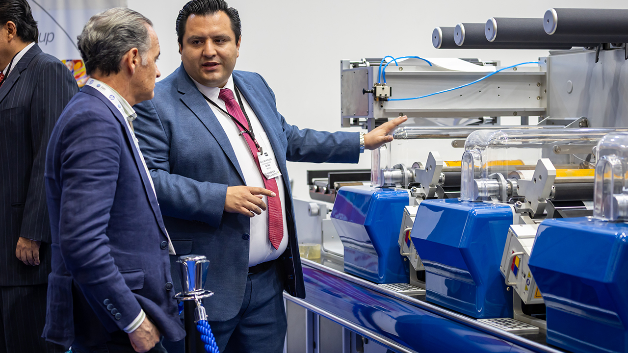 A man shows a flexo press to another man