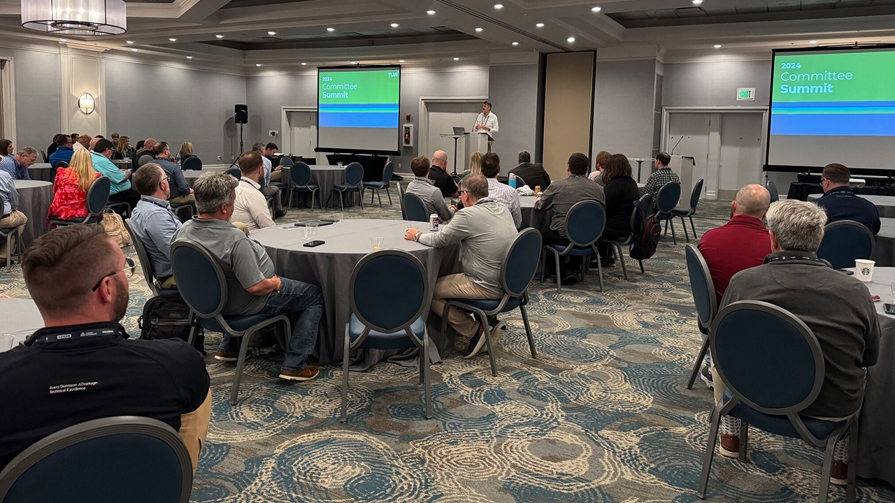 People sitting around tables at the TLMI Committee Summit