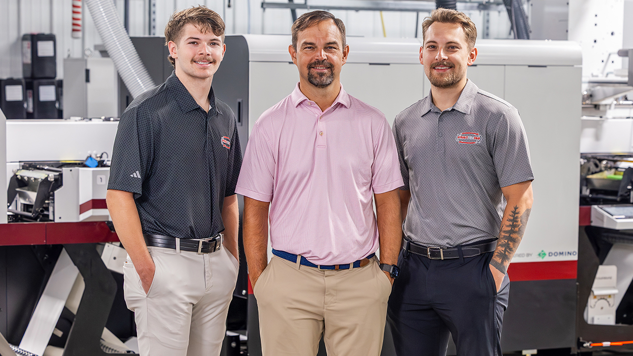 Simon Hicks, Joey Hicks and Silas Hicks in front of the Mark Andy DSiQ at PrintCo 360