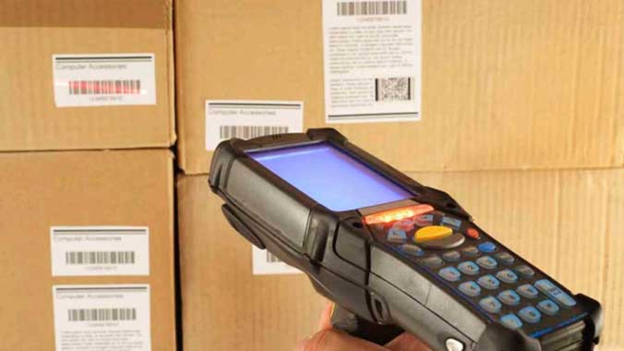 A hand-held scanner being used to read barcodes in a warehouse