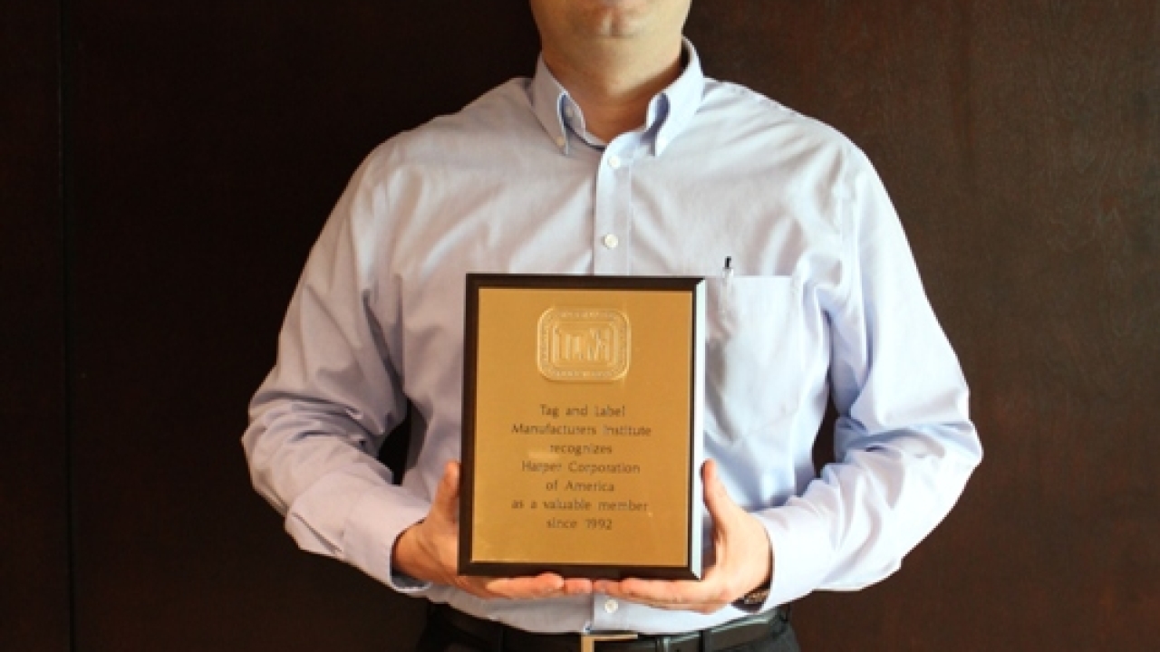 Harper receives bronze anniversary plaque from TLMI Harper receives bronze anniversary plaque from TLMI
