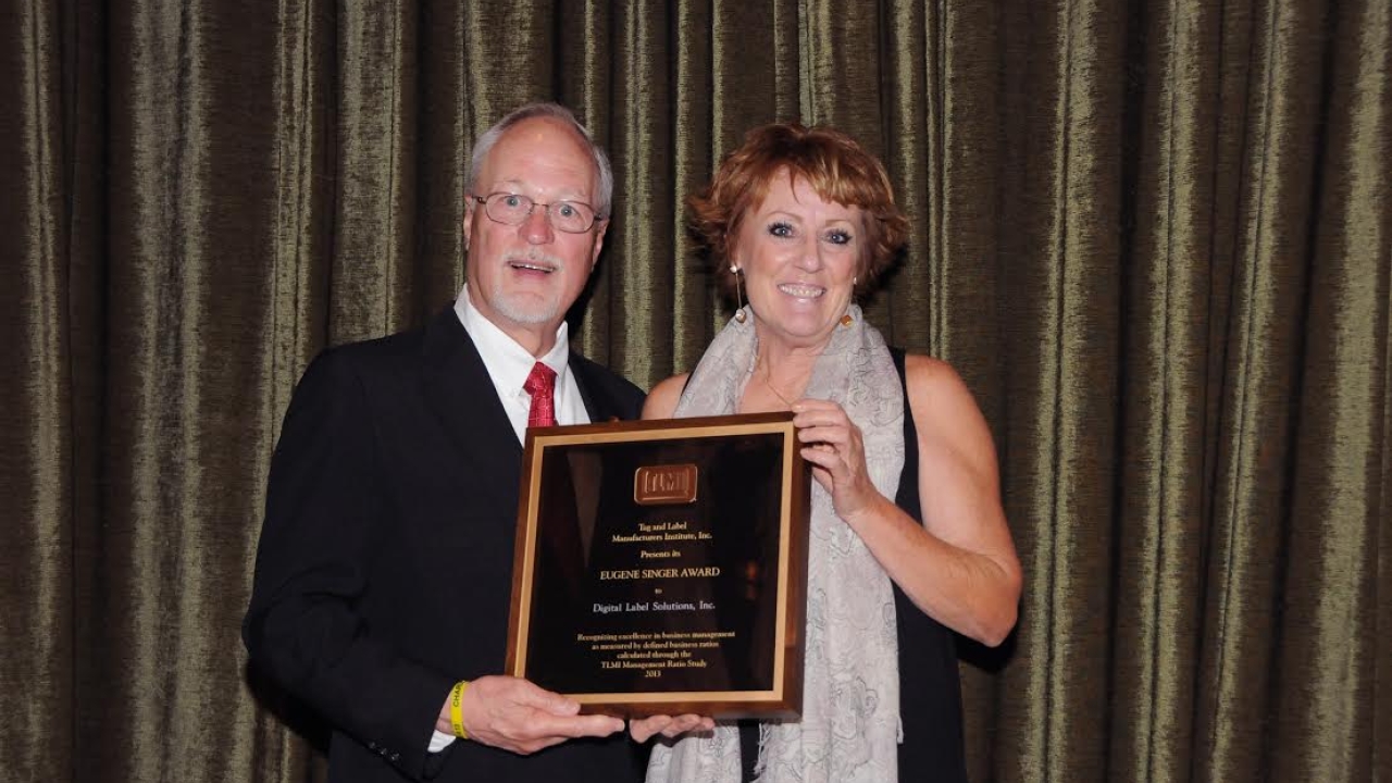 Dave McDowell TLMI Chairman awards Sandy Petersen of Digital Label Solutions with Eugene Singer Award