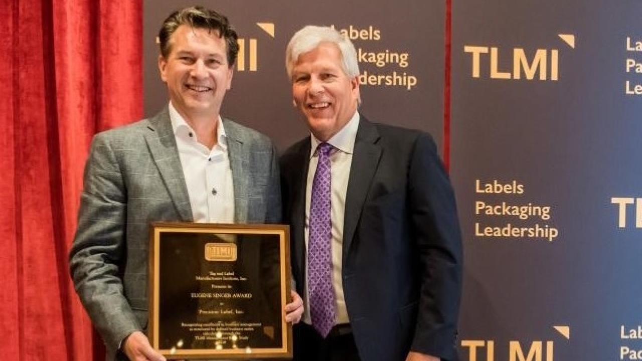 Sandy Petersen of Digital Label Solutions accepts the Eugene Singer Award from TLMI chairman Craig Moreland. Sandy Petersen of Digital Label Solutions accepts the Eugene Singer Award from TLMI chairman Craig Moreland.