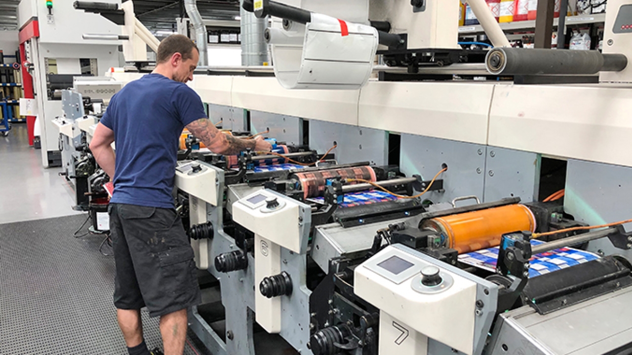 Printing press operator at Hamilton Adhesive Labels, running a label job using Asahi AWP flexo plates.