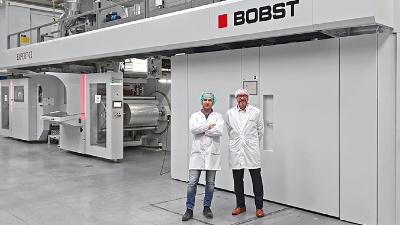 L-R: Alessandro Marino, technical Director, AMB; Alberto Vaglio Laurin, business director Italia, Bobst Italia, in front of the Expert CI flexo press in AMB production plant in San Daniele del Friuli, Italy