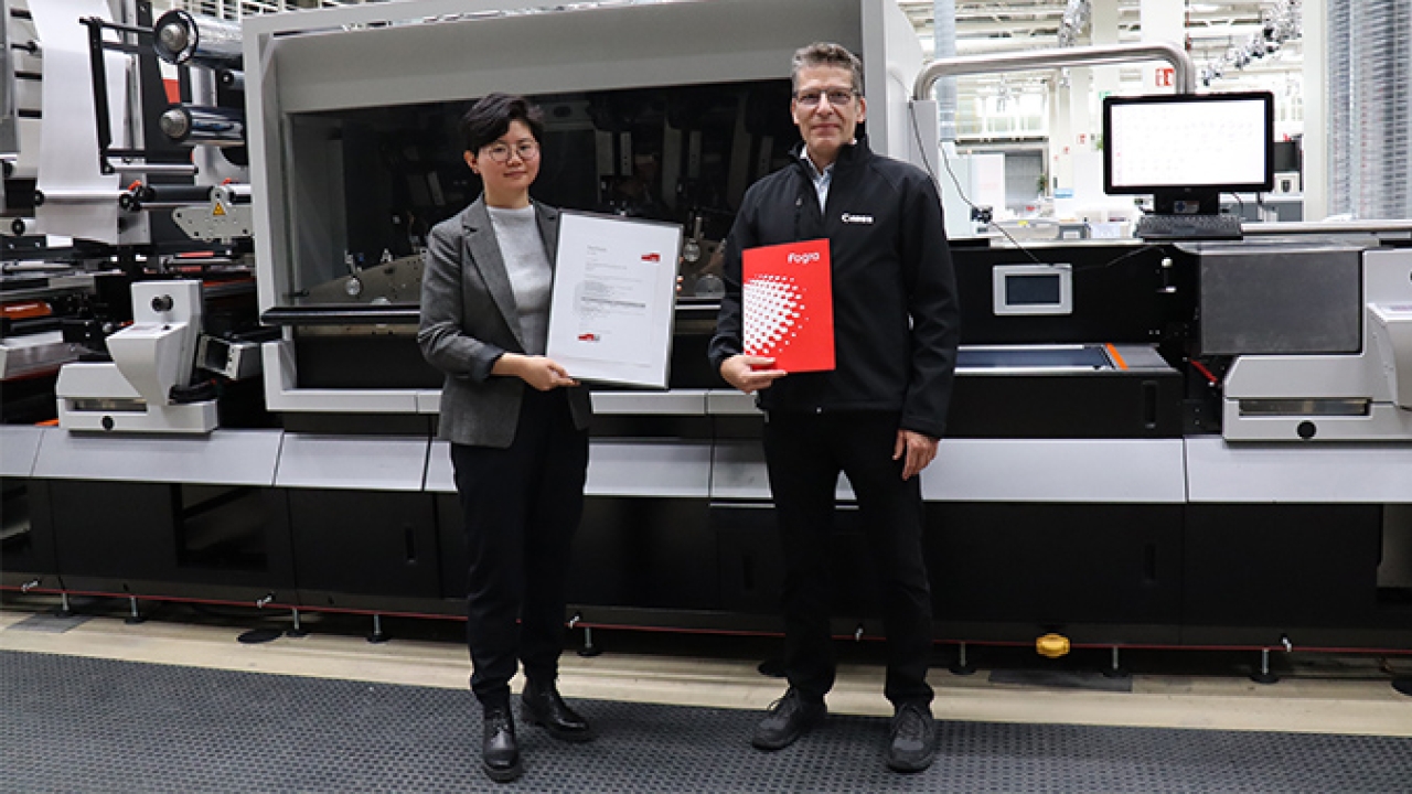 Yuan Li, responsible for pre-press technology at the Fogra Research Institute for Media Technologies, presents the Fogra certificate to Canon Production Printing’s color consultant, Jochen Schäffner Yuan Li, responsible for pre-press technology at the Fogra Research Institute for Media Technologies, presents the Fogra certificate to Canon Production Printing’s color consultant, Jochen Schäffner