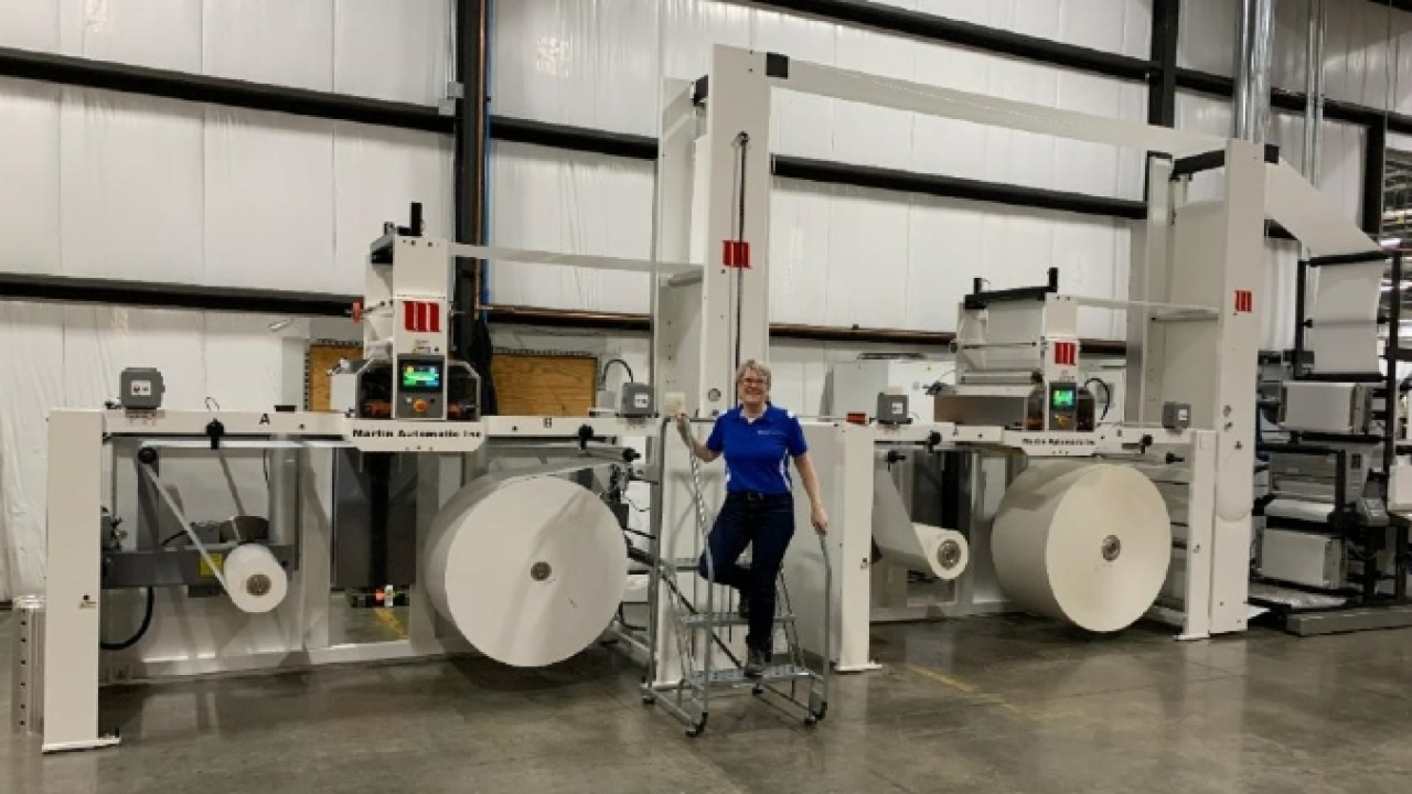 Sally Sann, label production manager, displays two Martin Automatic butt splicers installed in Wisconsin 