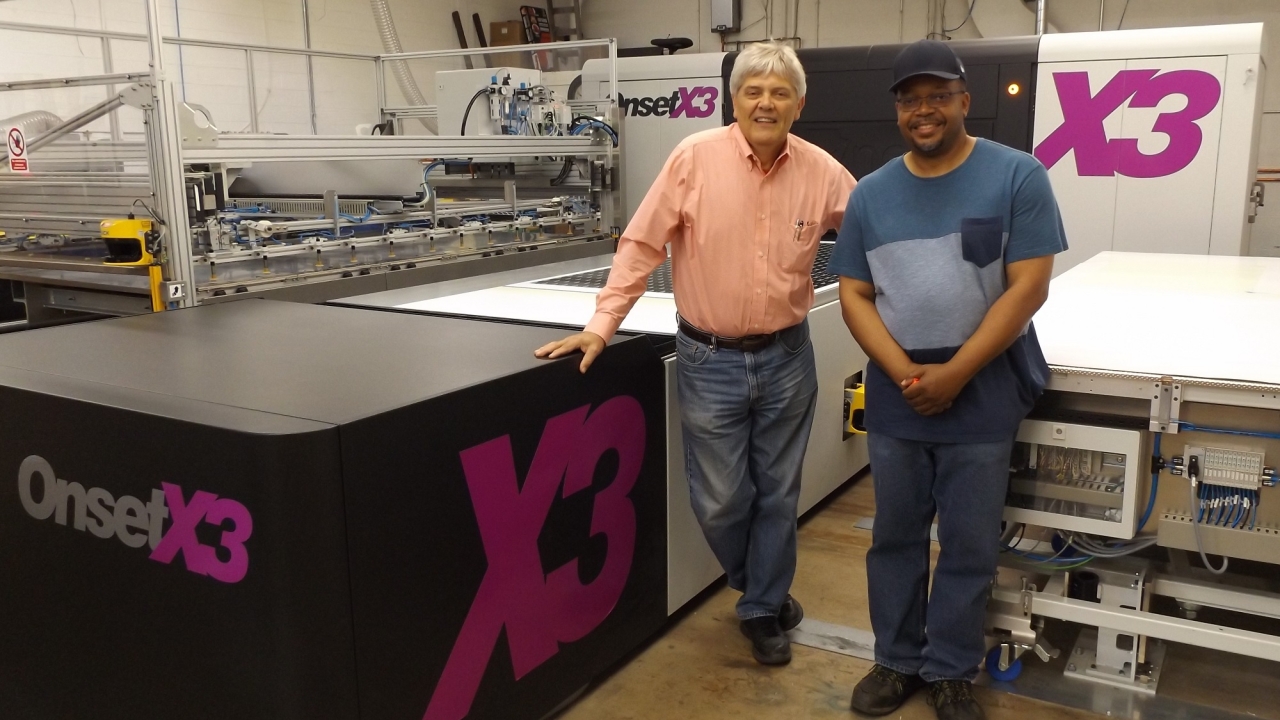 Mark Turk, left, president and CEO, and Alvin Page, inkjet press operator, alongside the Inca OnsetX3 with three-quarter automation at International Label, Elk Grove Village, Illinois. 