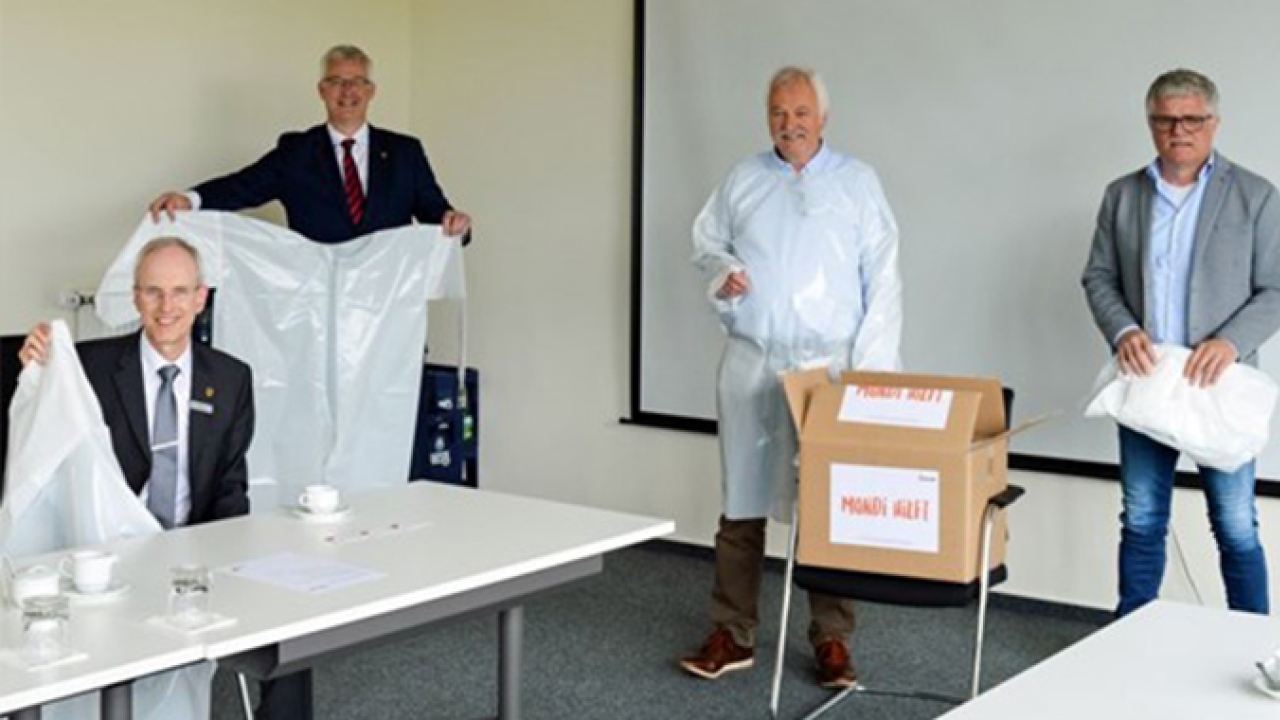 Mondi employees Alfons Kruse (second from right) and Detlef Stöppelmann (right) hand over the first 500 garments