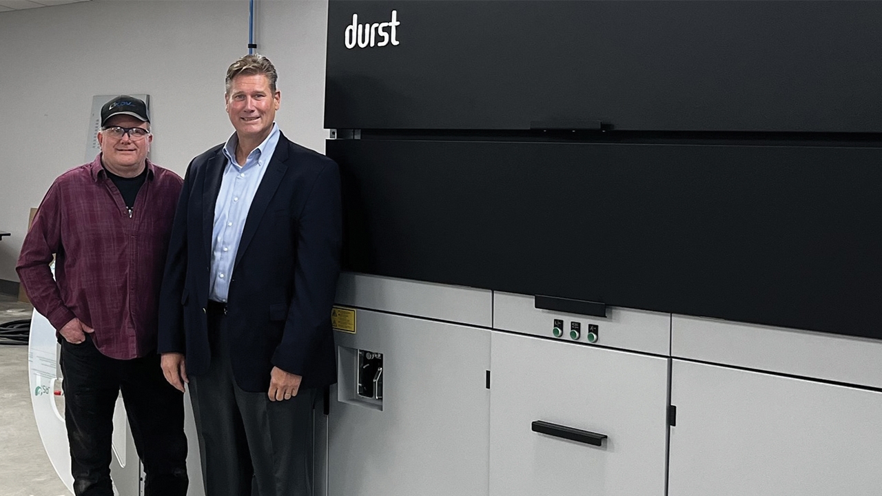  Keith Walz, KDV president and CEO with Ken Robinson with Durst vice president of operations at KDV, in front of newly installed Durst Tau RSCi press