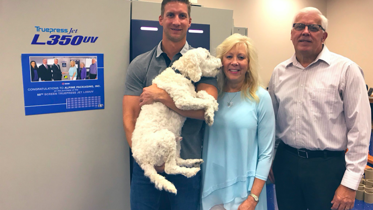Chase Lehigh, digital specialist, Jan Lehigh, president, and Bob Peretic, print products manager, with Alpine’s digital press and Scubby, the office mascot